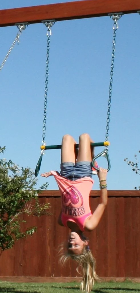 Child with ADHD hanging upside down on swing showing hyperactive behavior - Hope Springs Mental Health Clinic